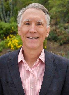 a portrait of strom thacker with the pitzer landscape behind him